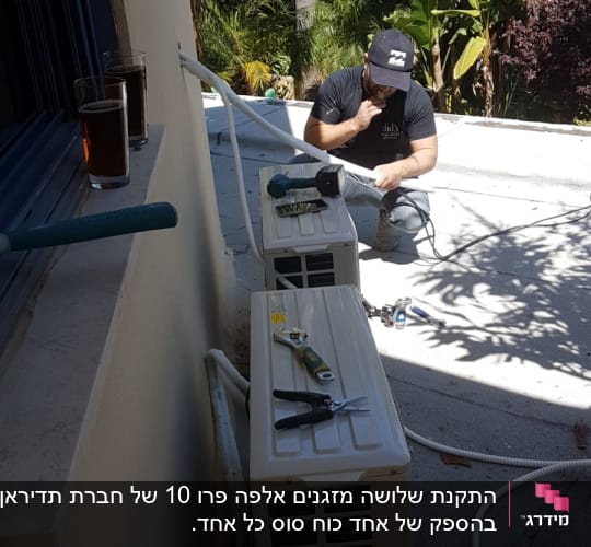 טכנאי מתקין מזגן עם כלים על הגג